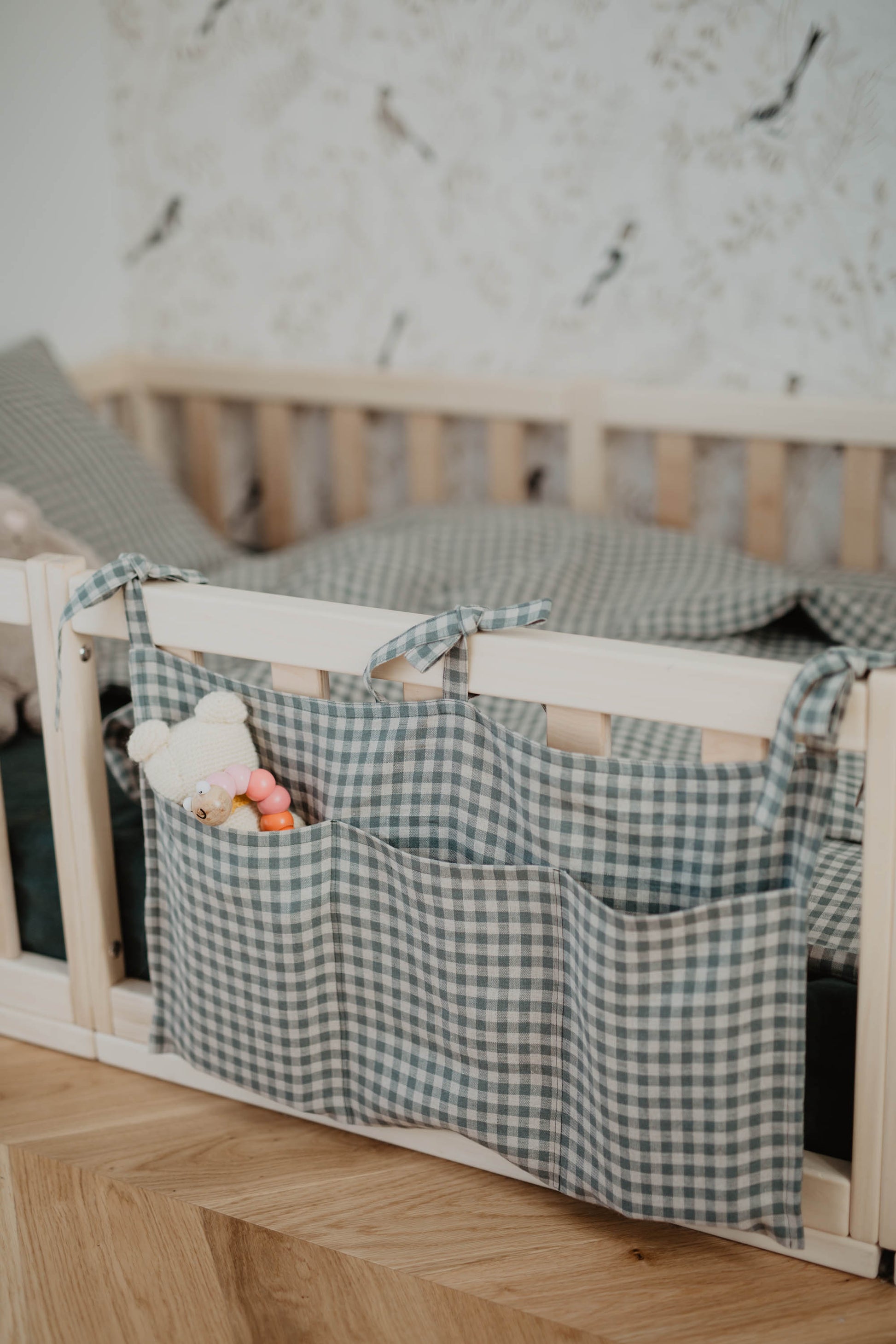 green check linen pocket organiser on toddler bed 