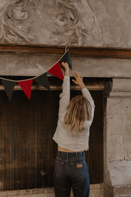 festive red and green linen bunting being hung on chimney