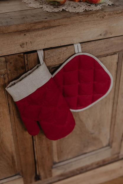 festive oven mitt in red with pot holder hanging of a cupboard