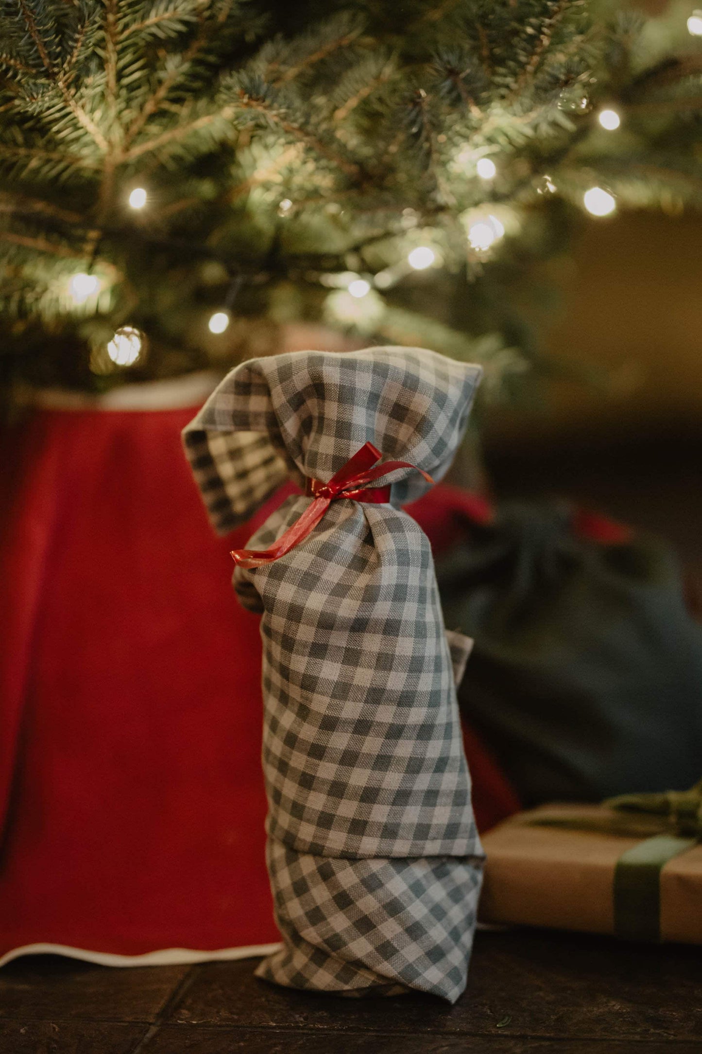 present wrapped in gingham linen wrapping cloth under tree 
